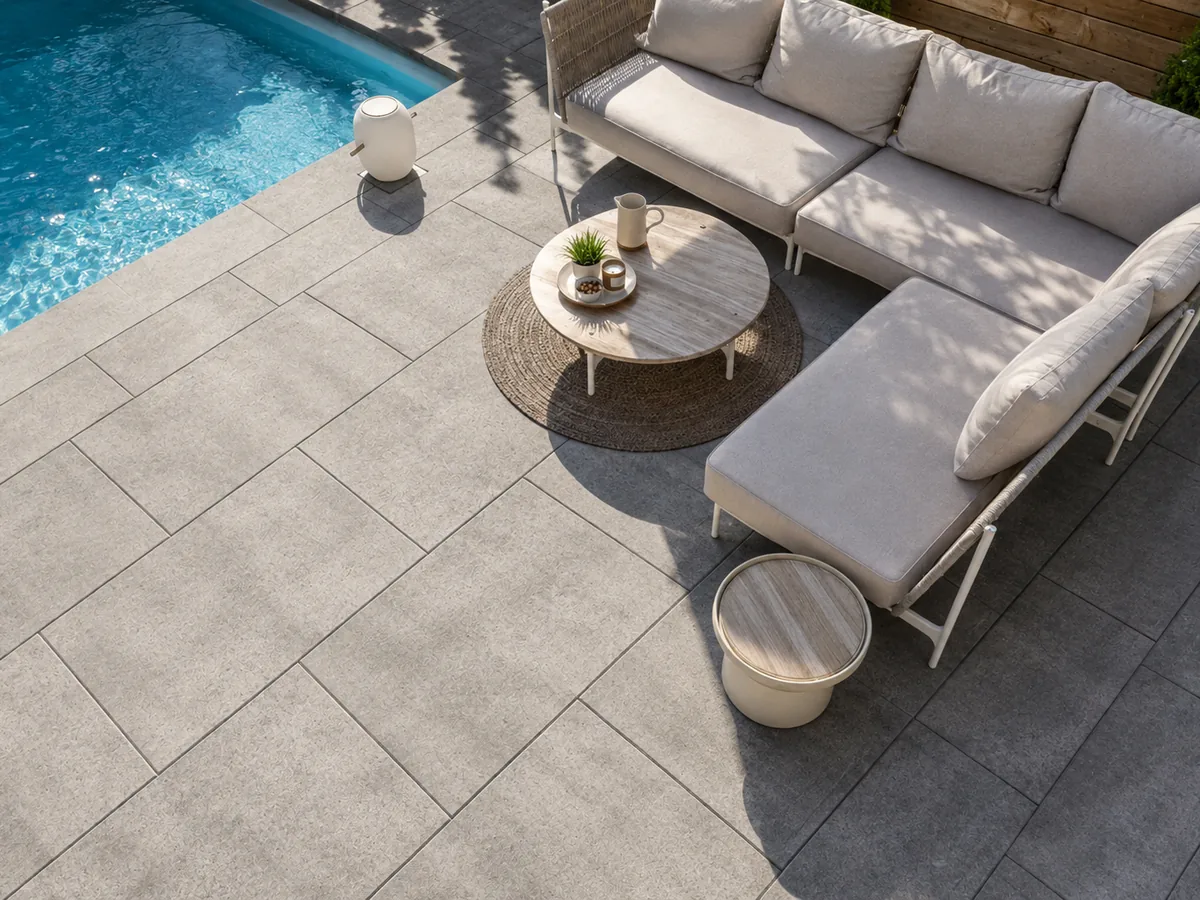 Large format grey slab pavers laid in a clean grid beside a pool
